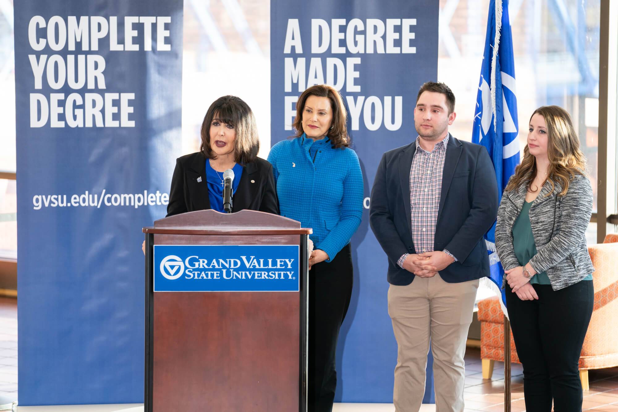 Governor Whitmer joins President Mantella and two students at a podium to announce the LEADS program.
